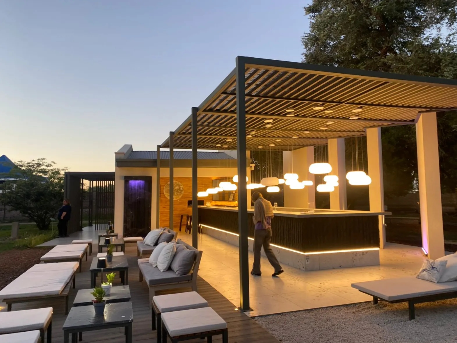 Espacio exterior con pérgola moderna iluminada al atardecer, ganador del 1er Premio Estilo Pilar 2023
