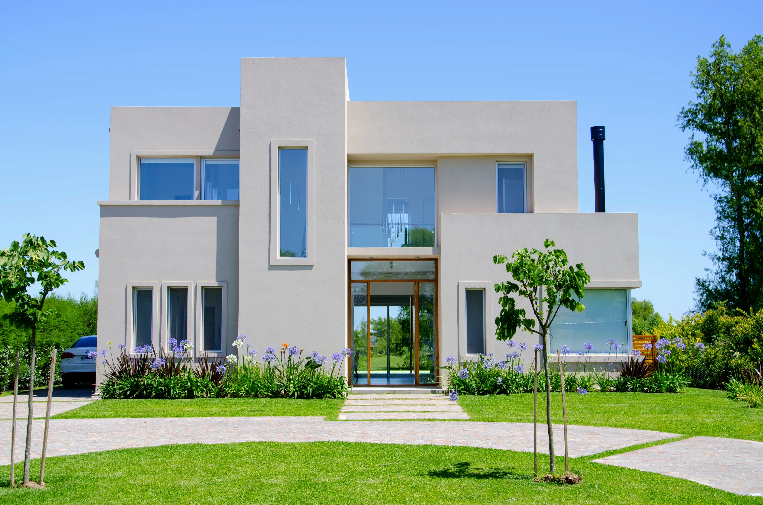 Casa cubista blanca de líneas modernas con doble altura vidriada